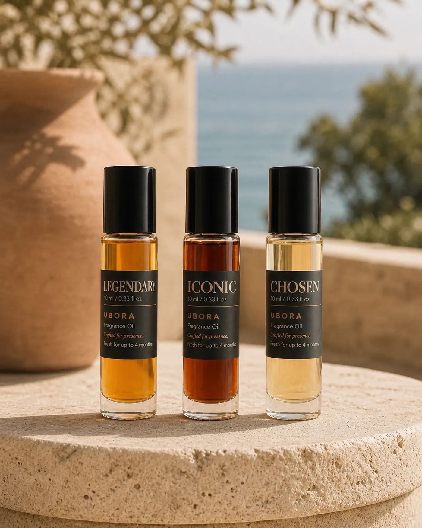 Three UBORA fragrance oils on a round travertine table